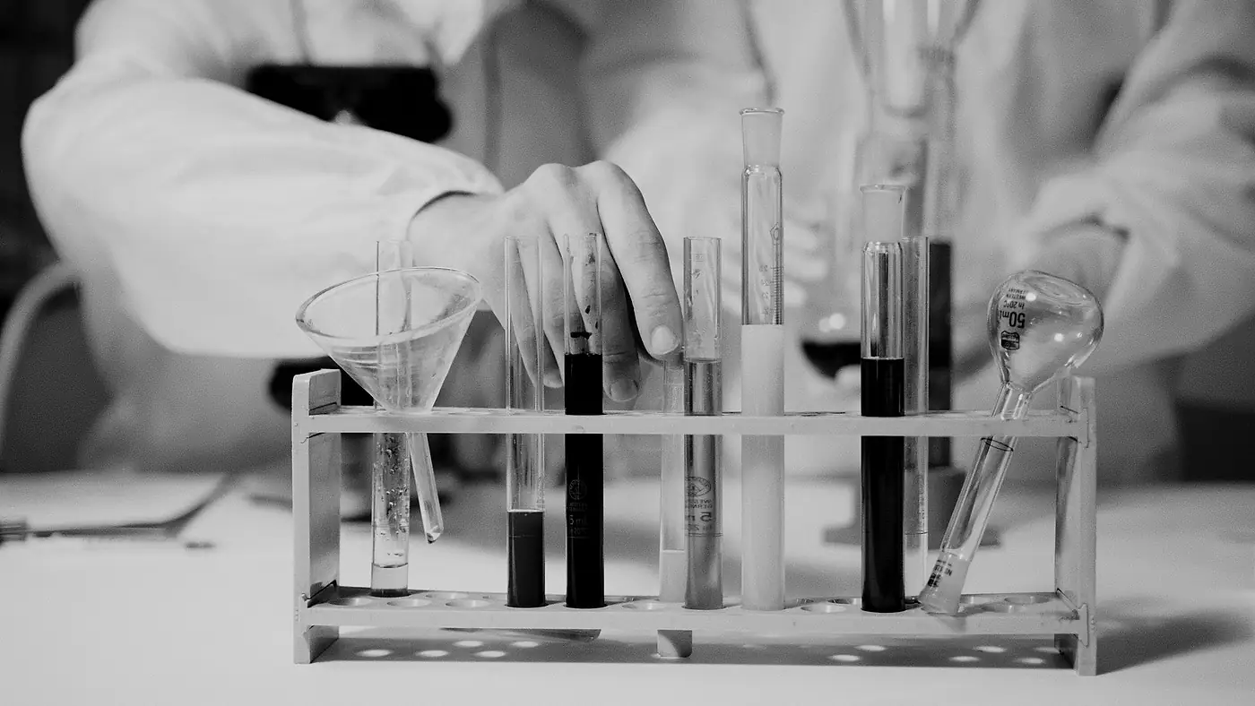 Laboratory technician handling test tubes, black and white