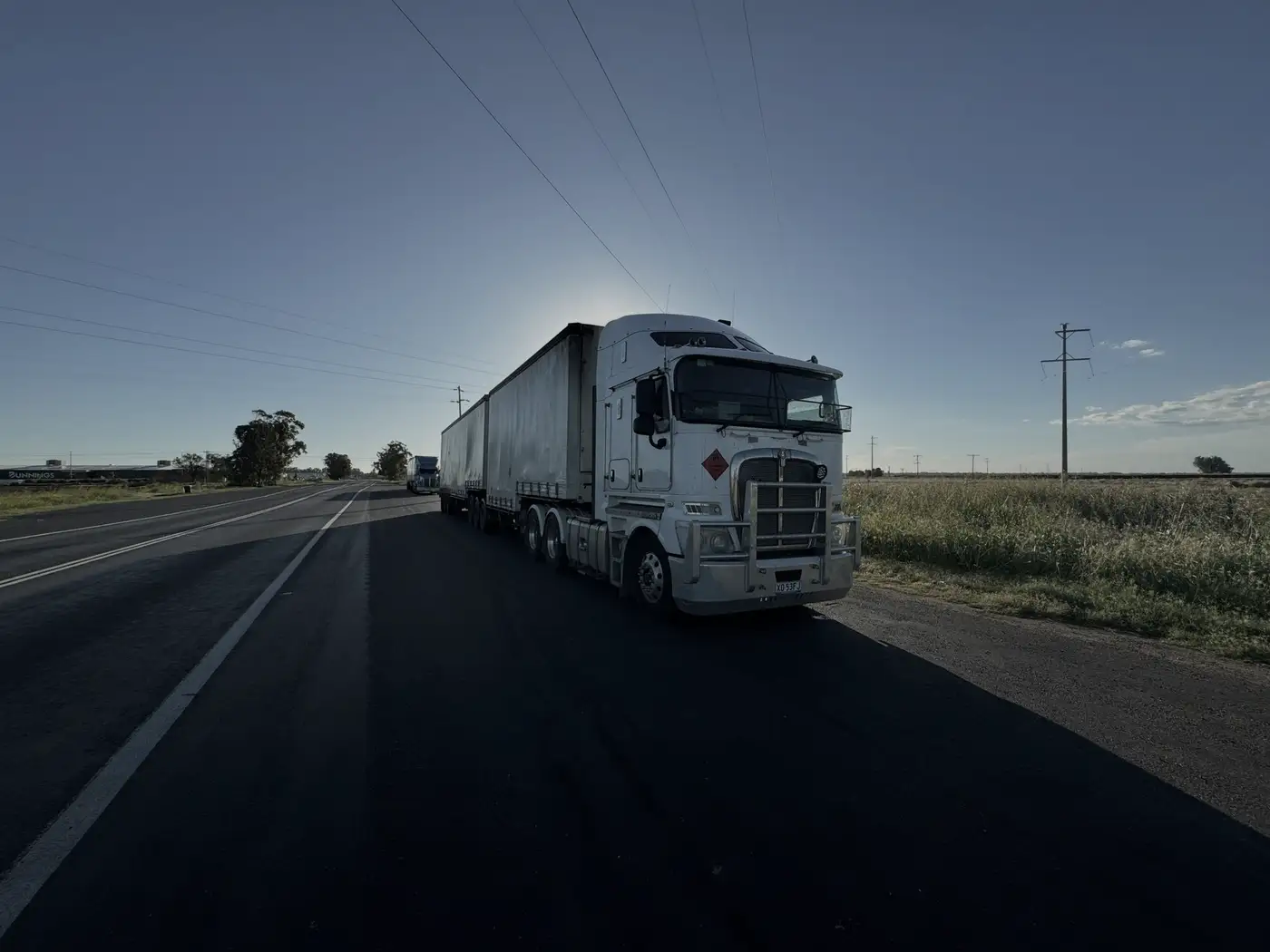 Heavy truck with trailers driving along a rural highway